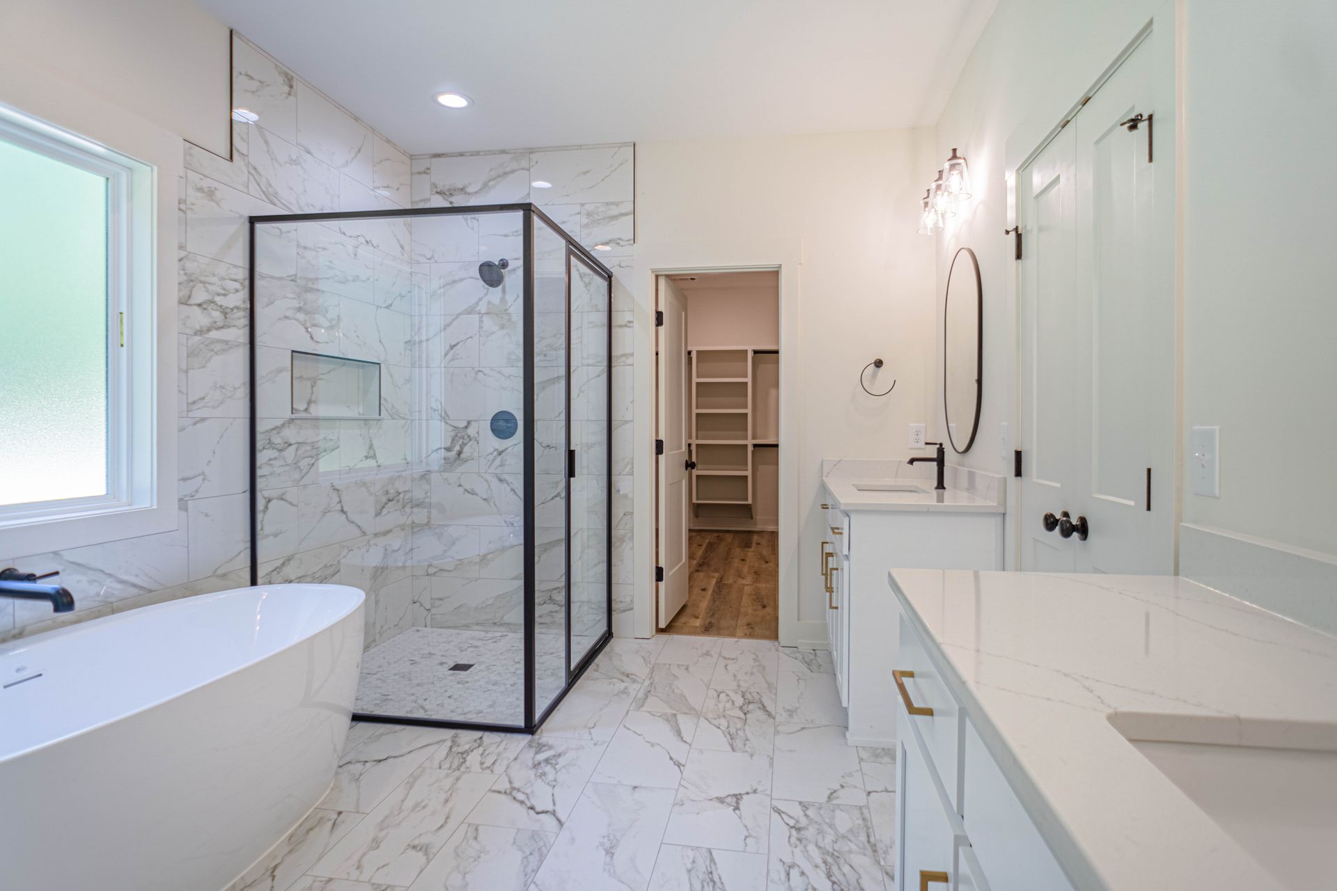 A bathroom with a tub , sink , shower and walk in closet.