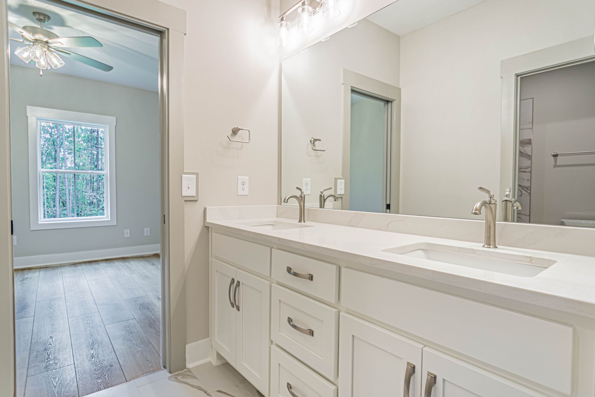 A bathroom with two sinks and a large mirror.