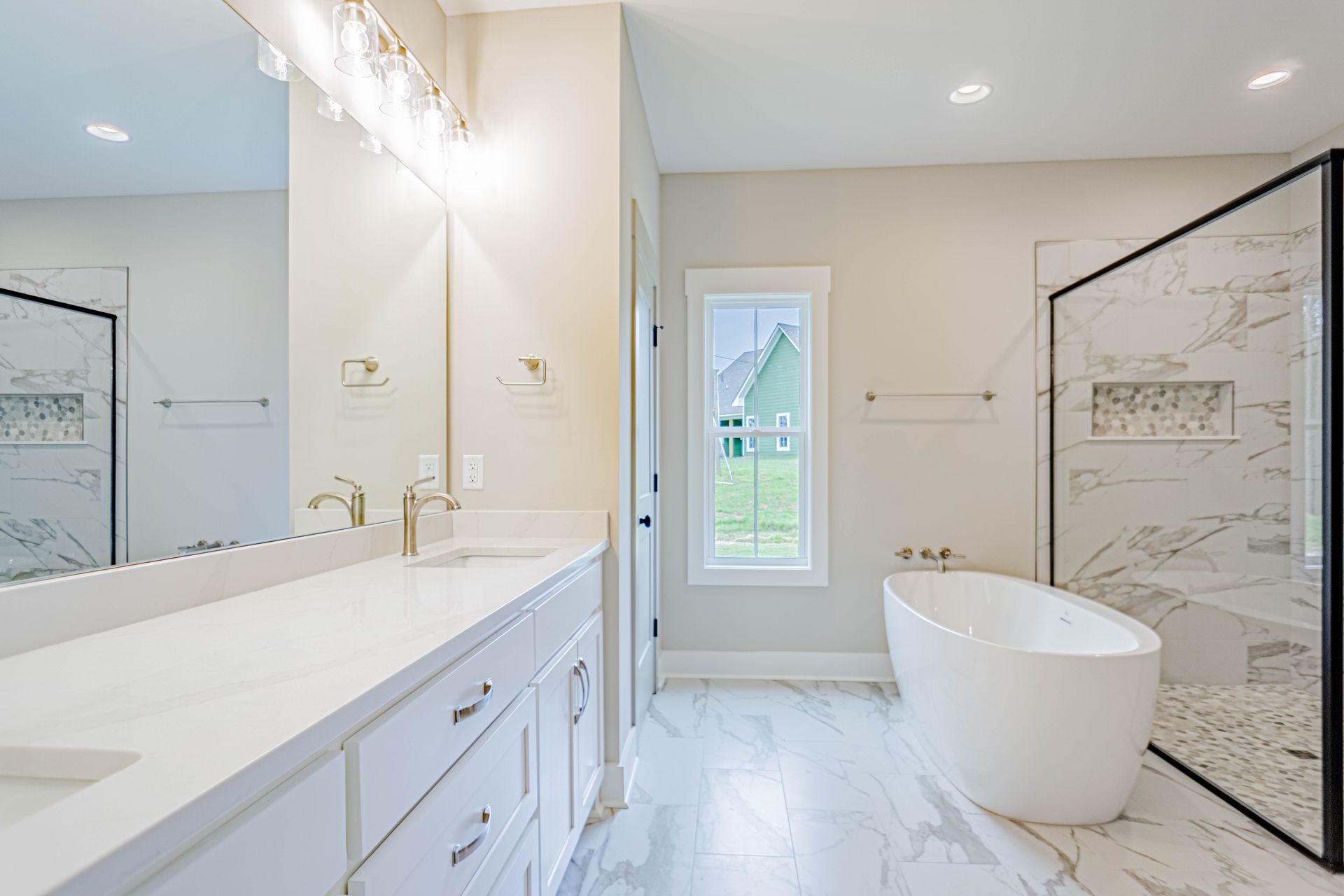 A bathroom with two sinks , a tub , and a walk in shower.