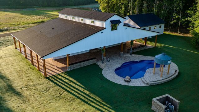 An aerial view of a house with a pool in the backyard.