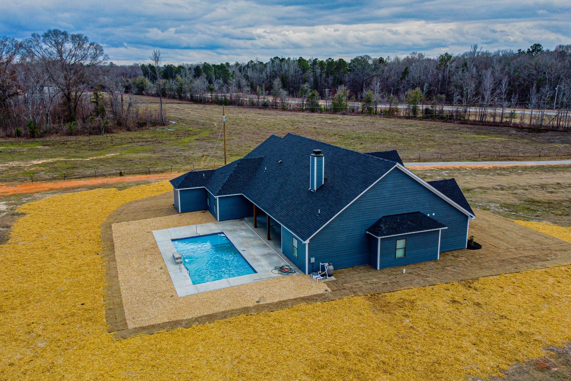 An aerial view of a house with a pool in the backyard.