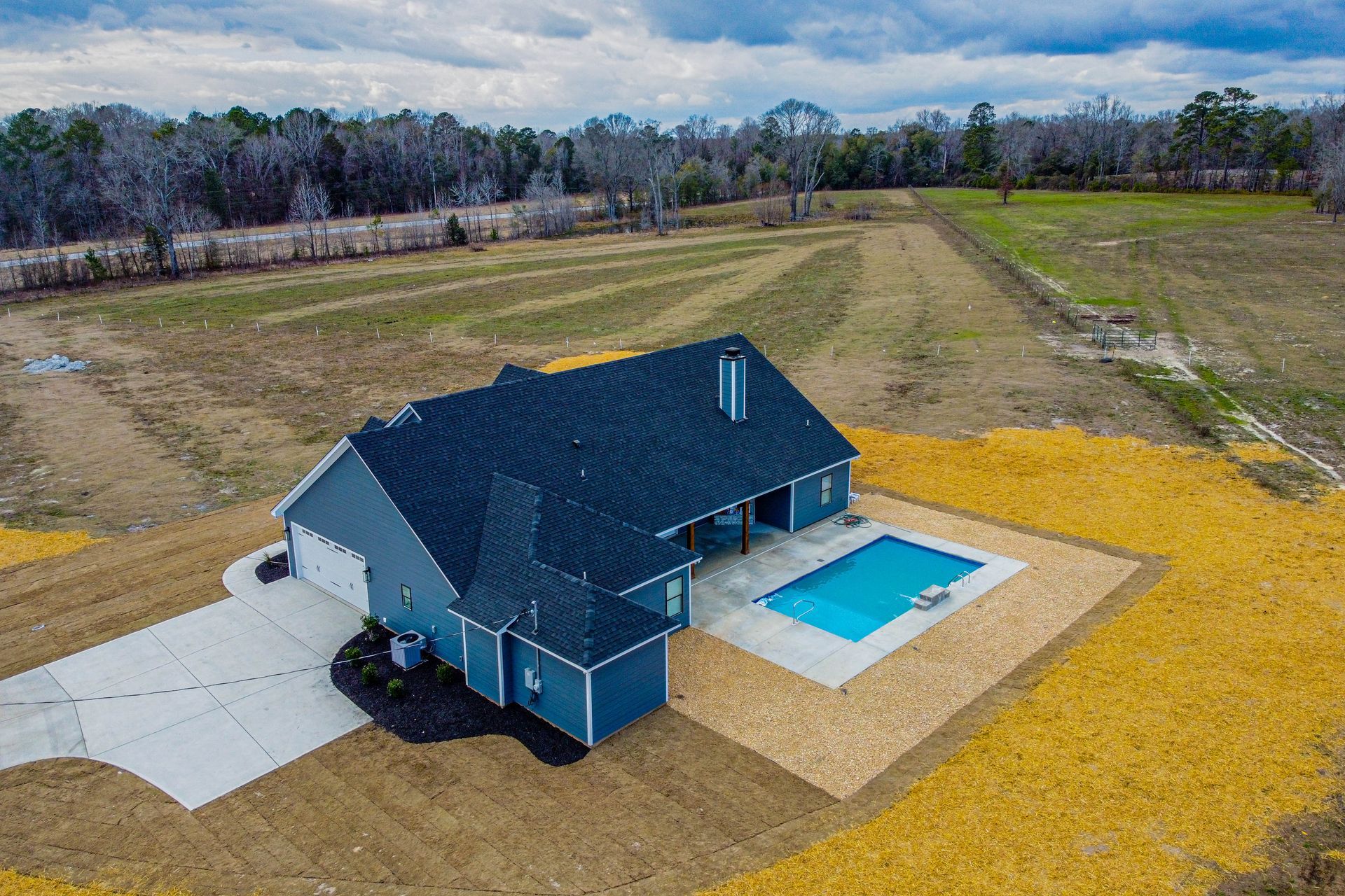 An aerial view of a house with a pool in the backyard.