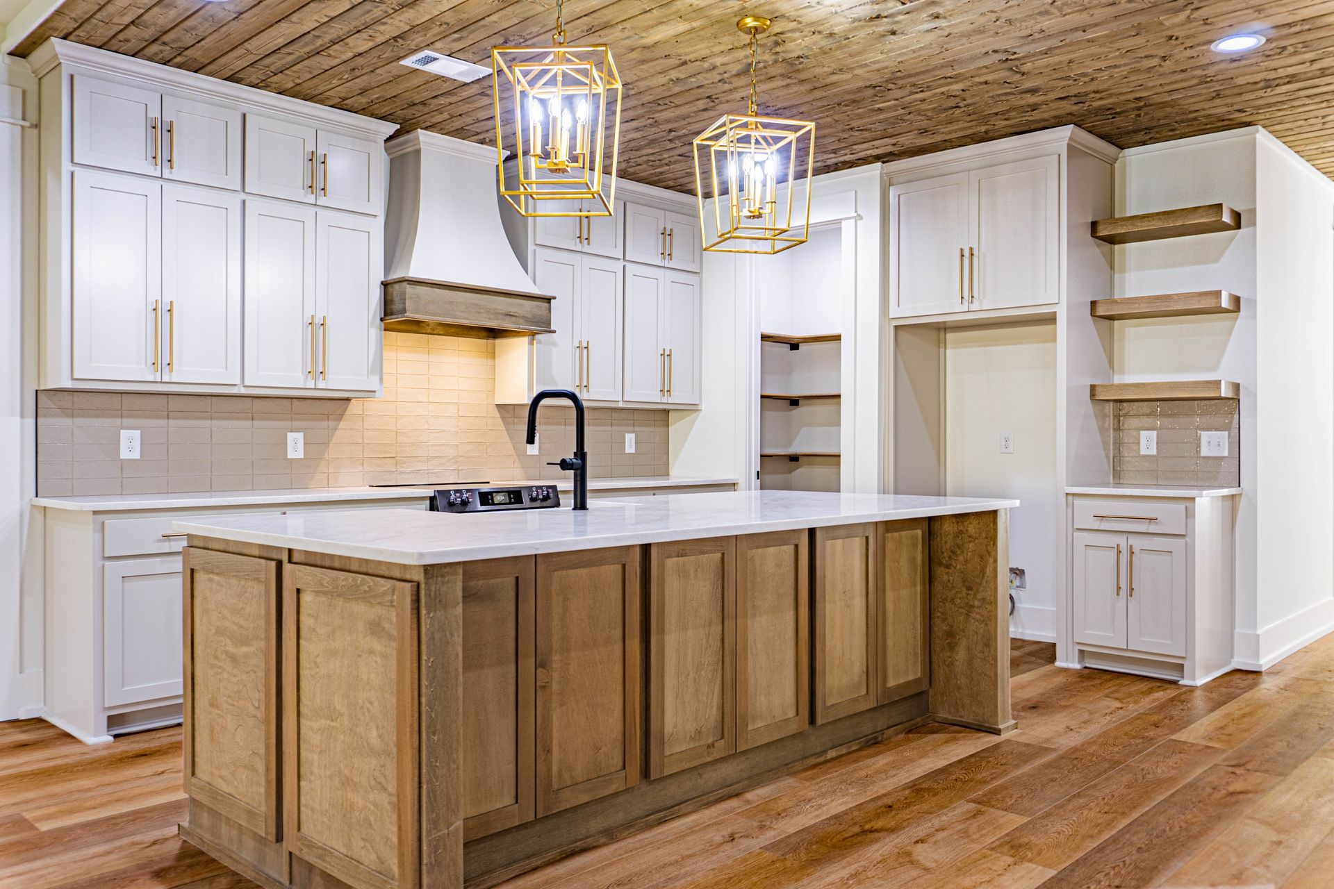 A kitchen with white cabinets and a large island in the middle.