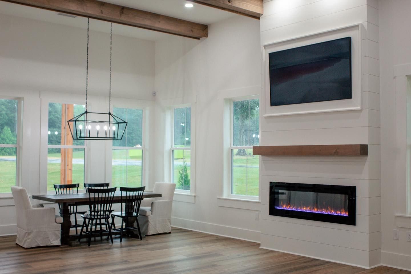 A living room with a fireplace , dining table and chairs.
