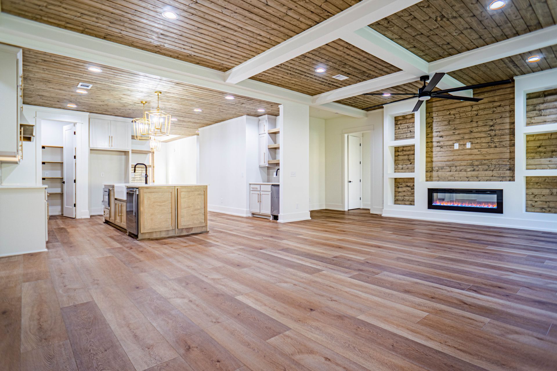 A large empty room with hardwood floors and a fireplace.