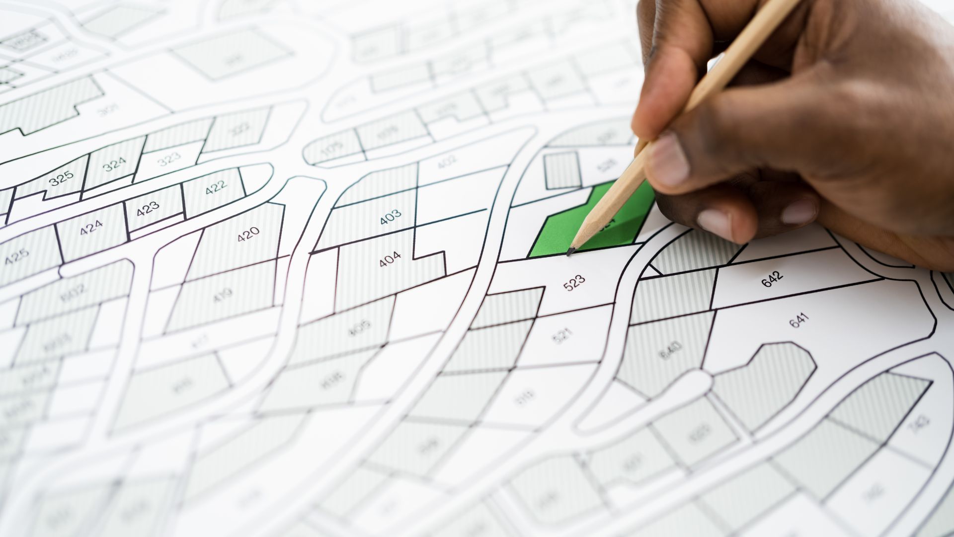 A person is drawing a map with a green square in the middle.