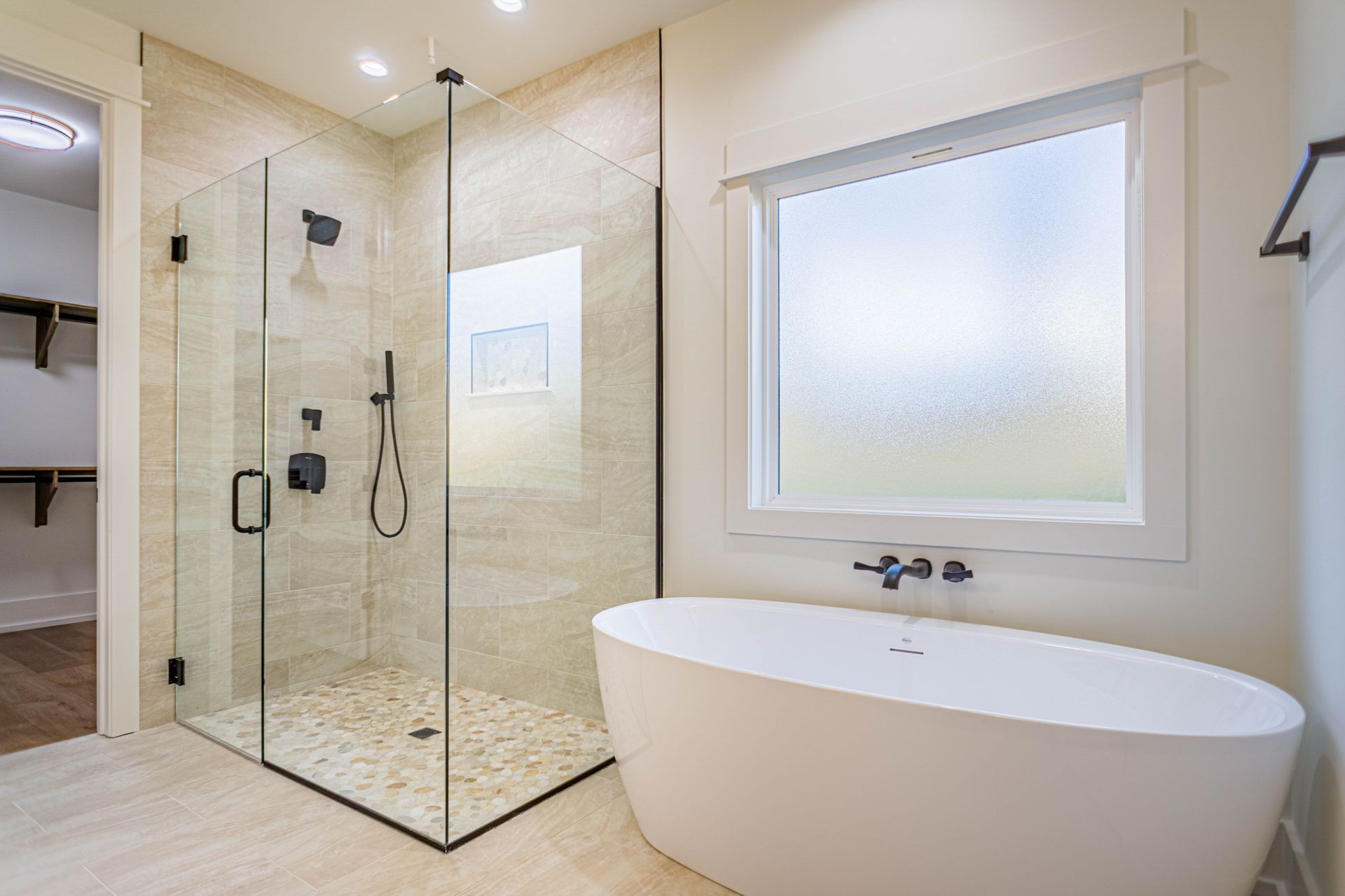 A bathroom with a tub , shower , and window.