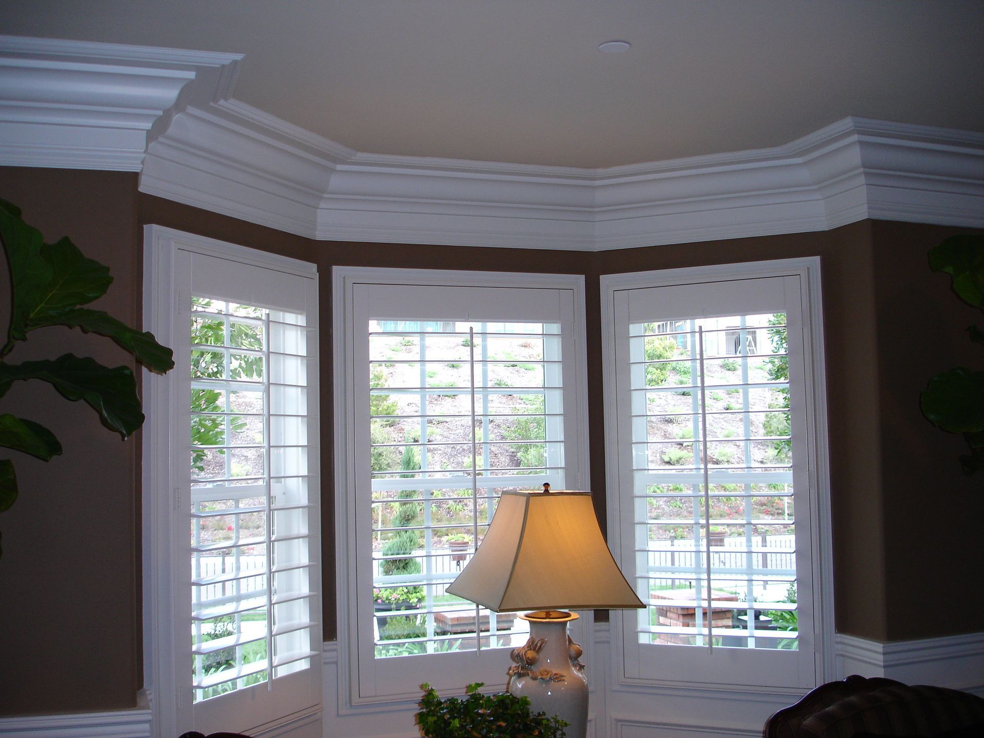 Lounge with white framed bow and bay windows and  white  American shutter blinds