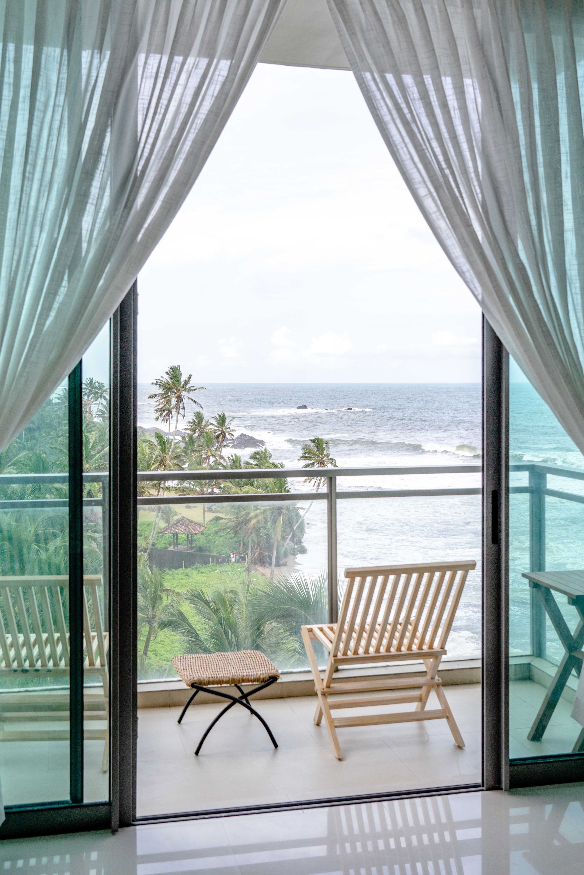 Glass sliding doors opening to ocean view of a veranda