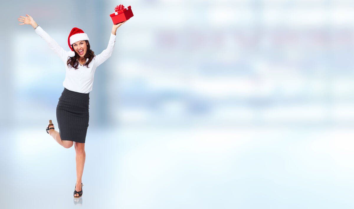 happy business woman with christmas hat and present in hand
