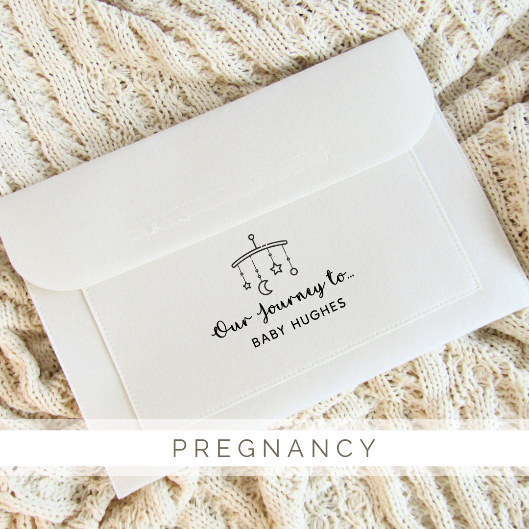 A white envelope is sitting on top of a knitted blanket.