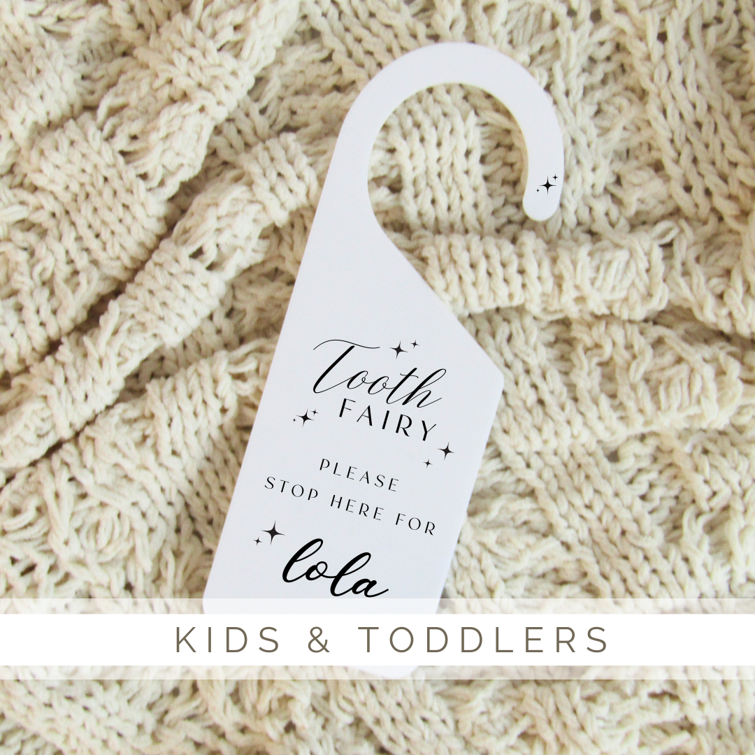 A tooth fairy sign is hanging on a knitted blanket.
