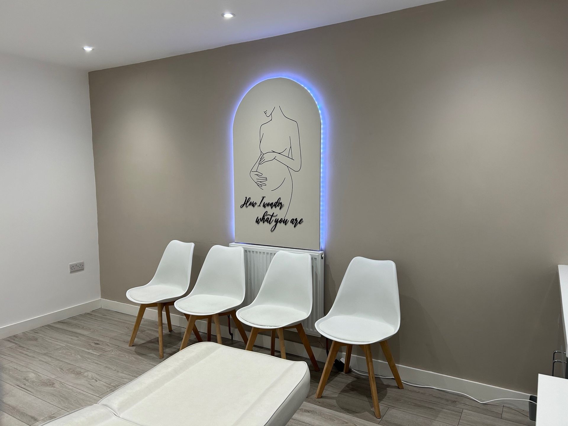 A waiting room with white chairs and a clock on the wall.