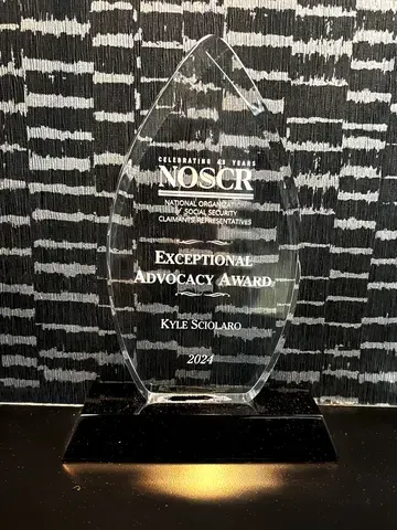 Glass award on black base with “Exceptional Advocacy Award” and NOSCR logo.