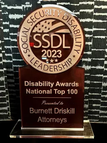 Trophy for Social Security Disability Leadership. Awarded to Burnett Driskill Attorneys, National Top 100. Brown and clear design.