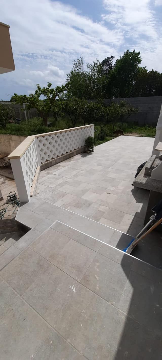 Un patio con una recinzione e delle scale per accedervi.