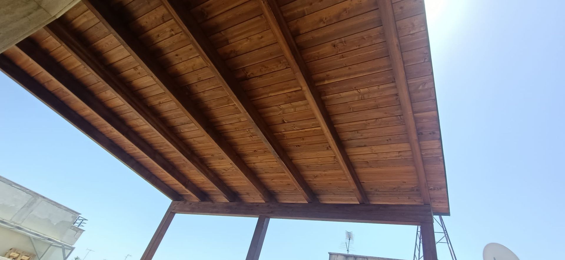 Un tetto di legno con un cielo azzurro sullo sfondo.