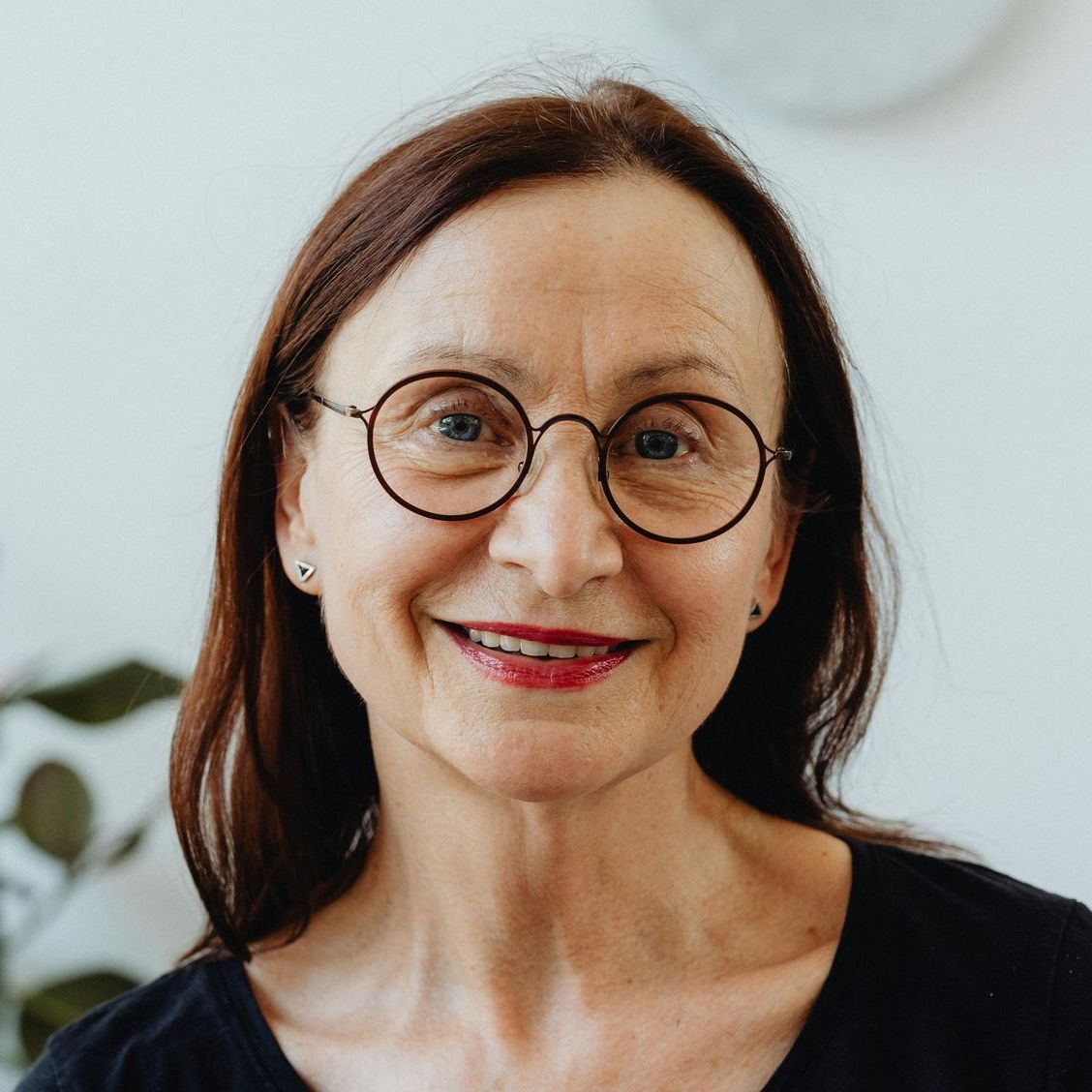A woman wearing glasses and a black shirt is smiling for the camera.