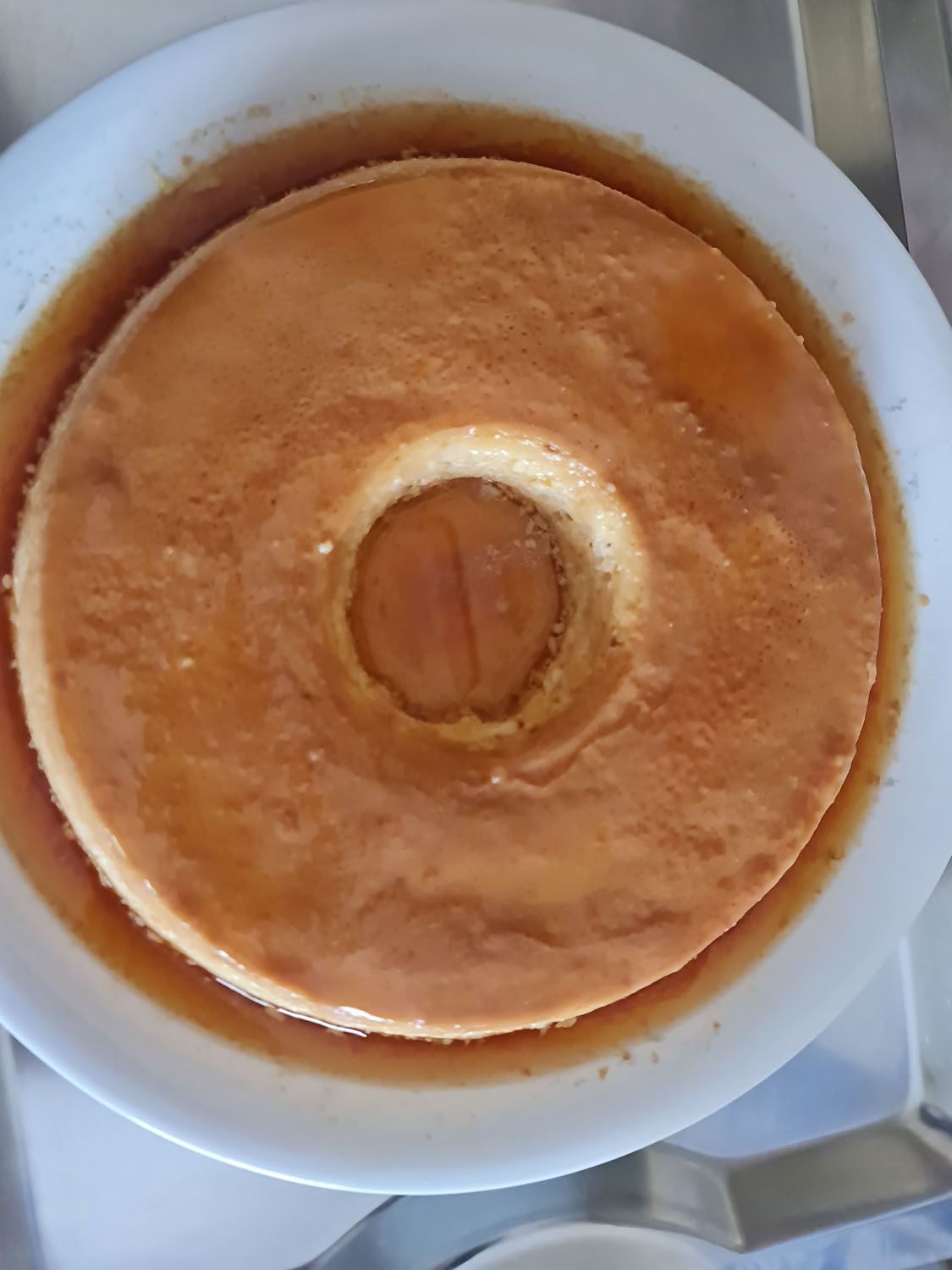 Um prato branco coberto com um bolo com um buraco no meio