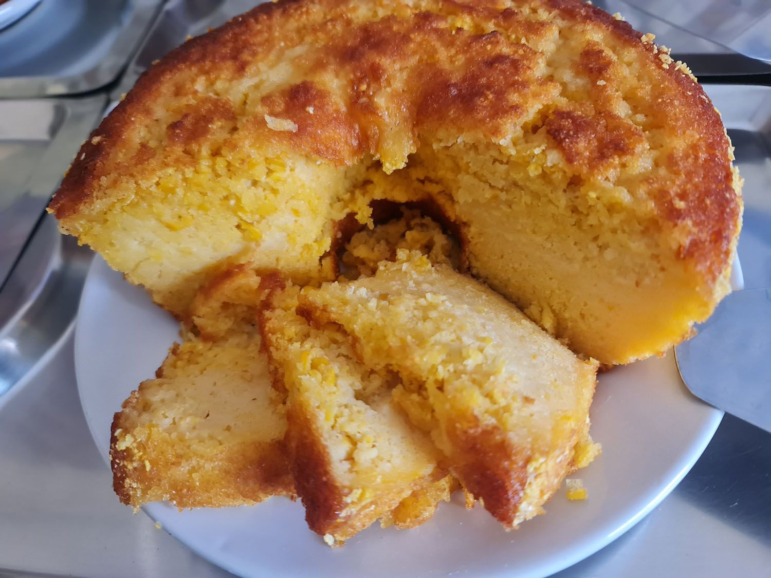 Um pedaço de pão de milho está sobre um prato branco.