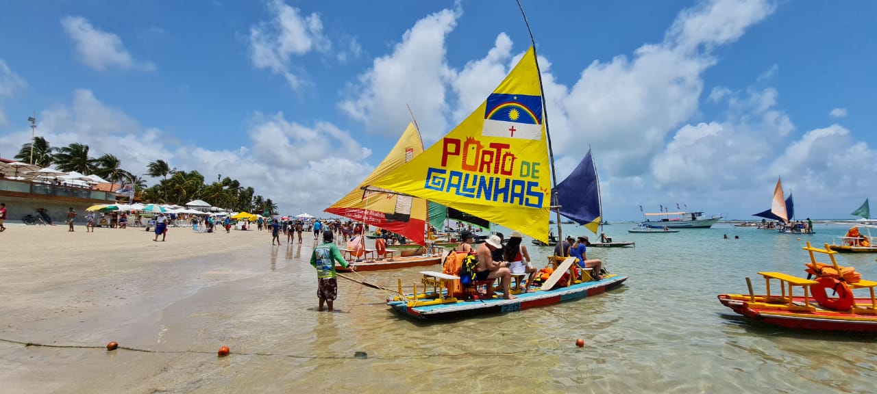 Um barco com uma vela amarela que diz porto de esmeraldas