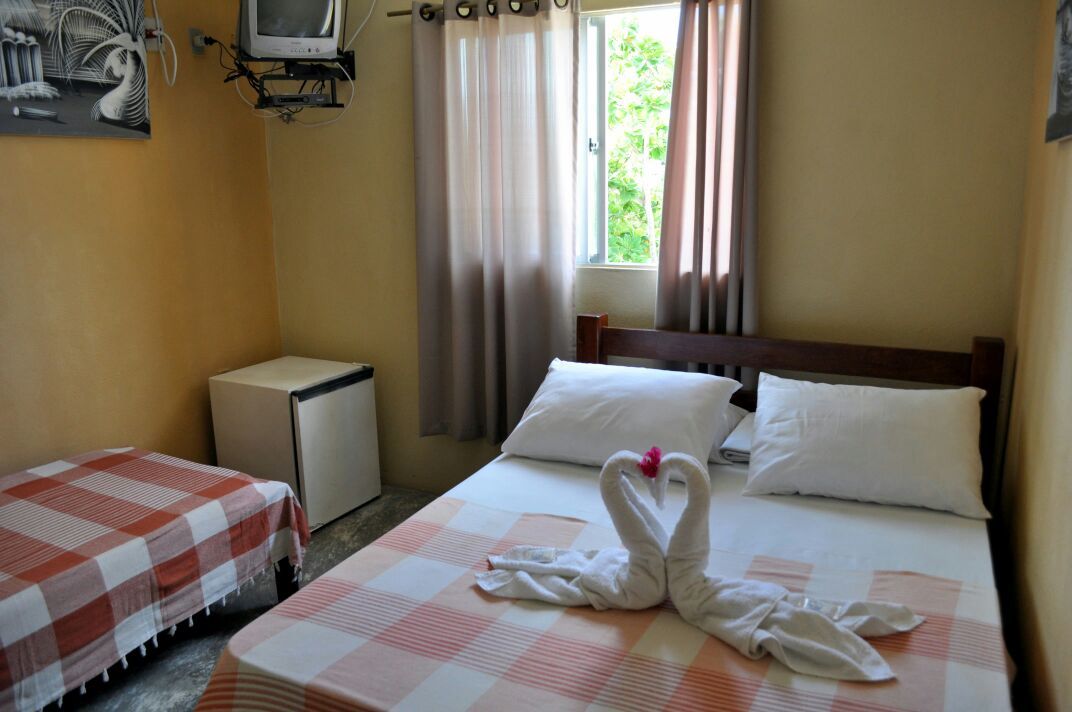 Um quarto com uma cama e dois cisnes feitos de toalhas.