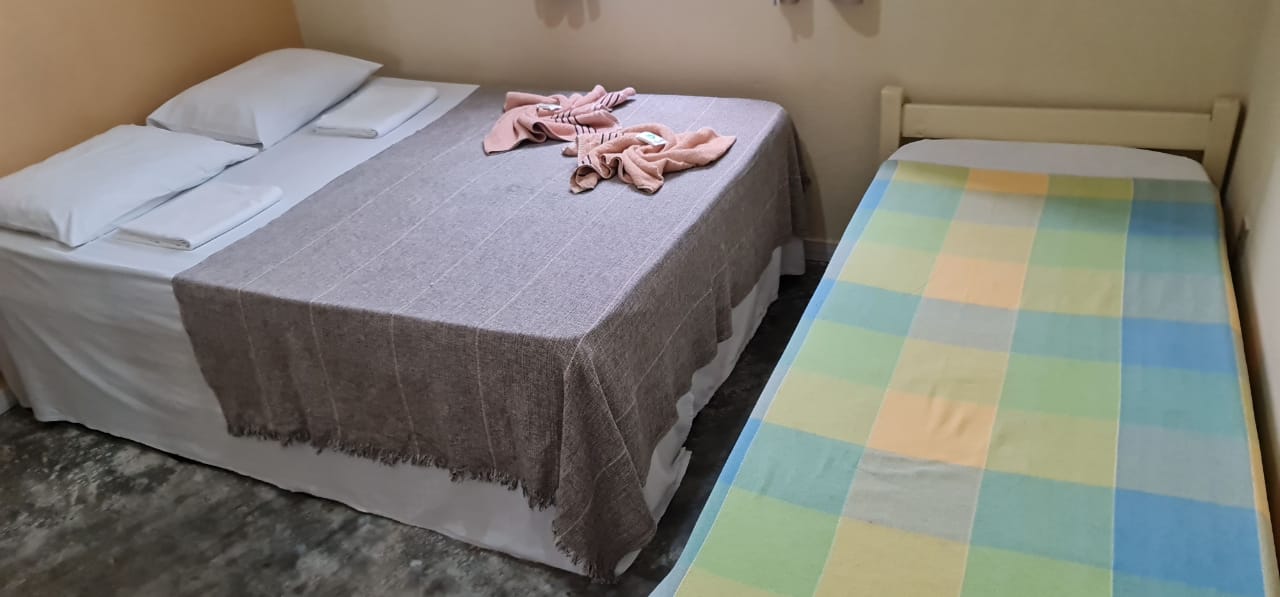 Há uma cama e uma cama de solteiro no quarto.