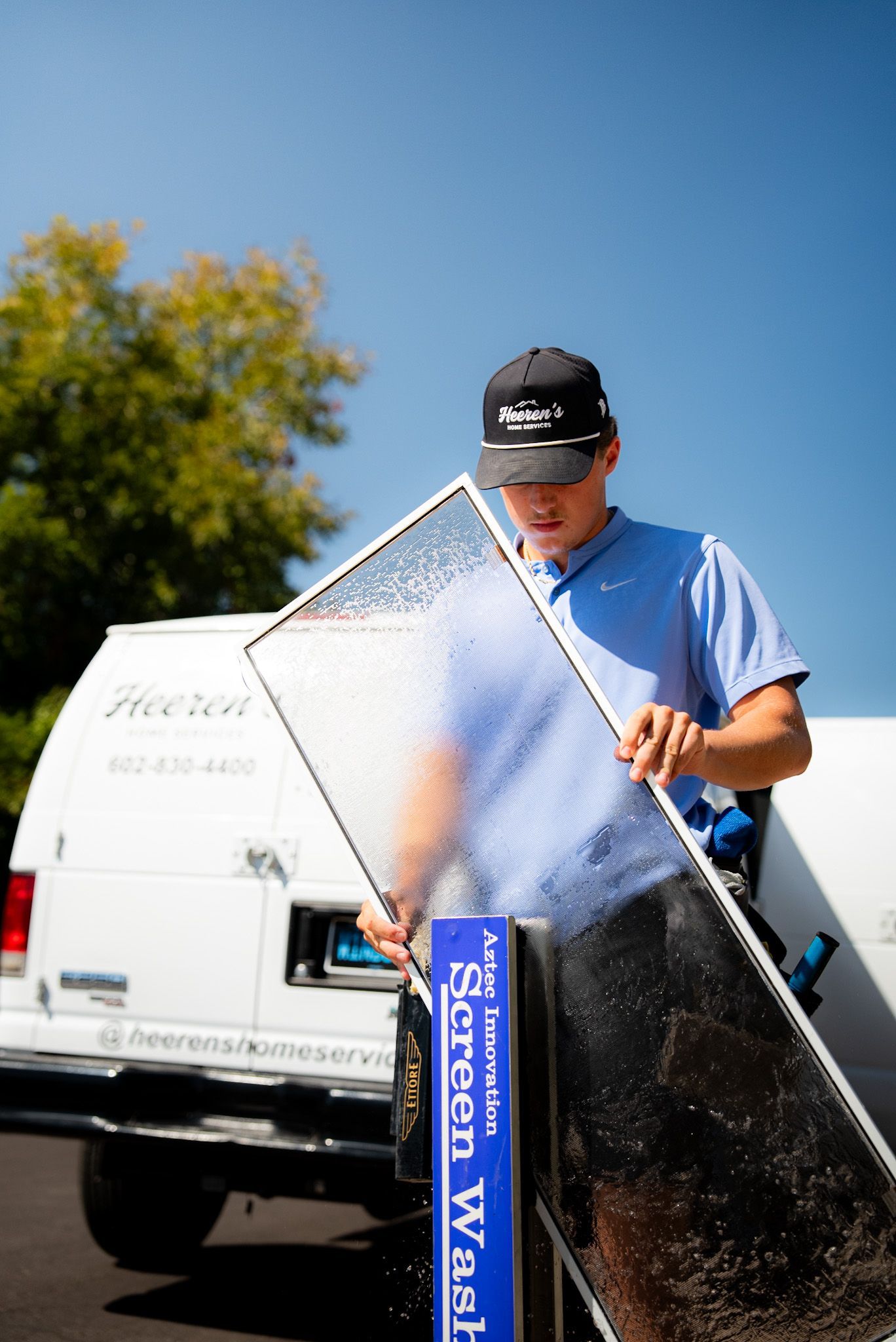A man is standing on a sidewalk next to a white van.
