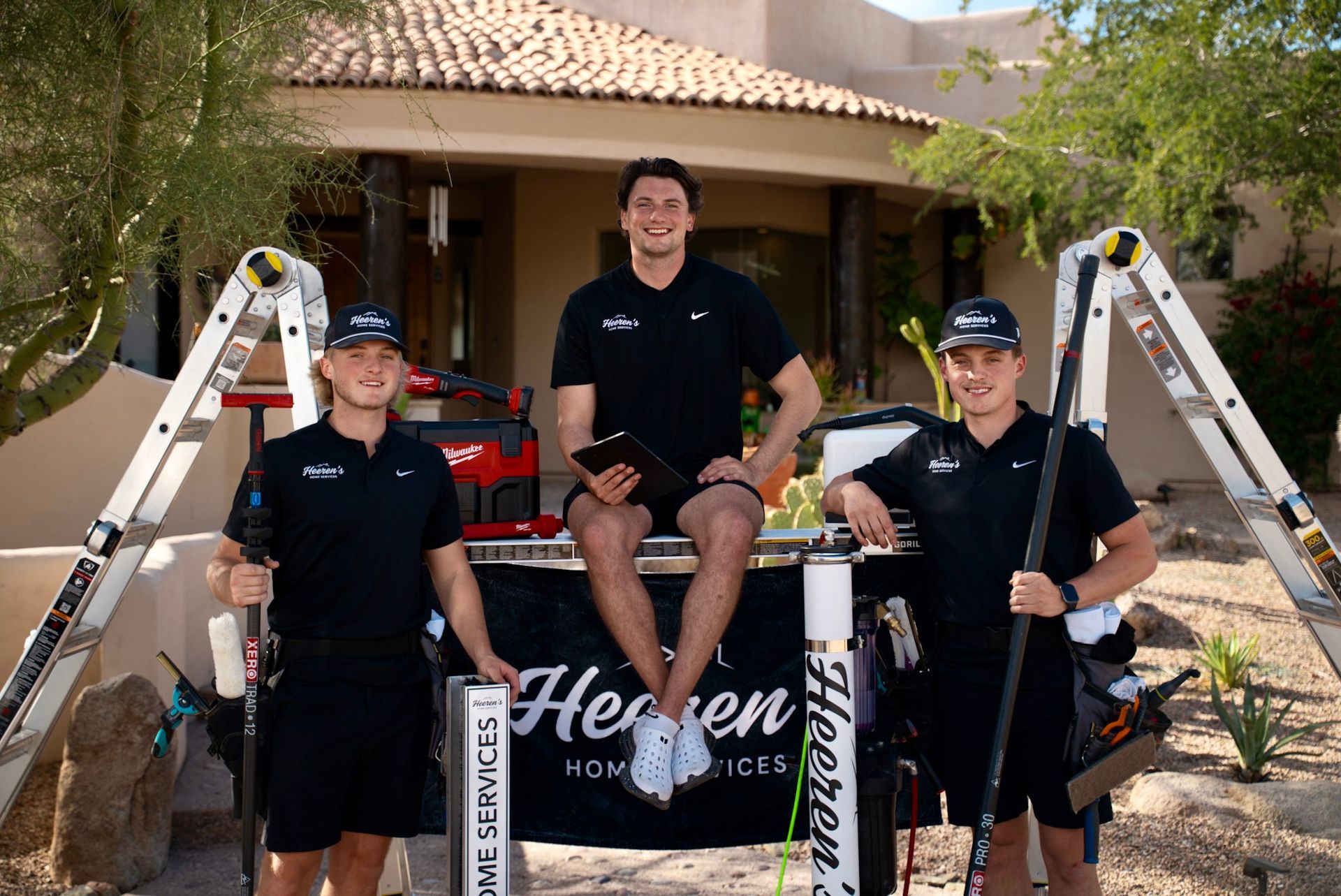 Two men are sitting on the side of a white van.