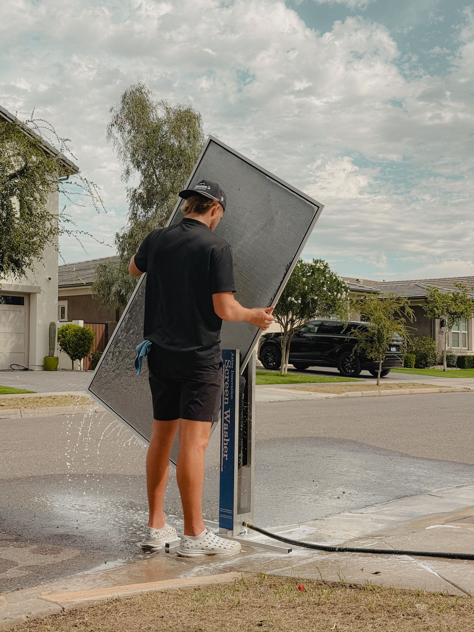 A man is standing on a ladder on the side of a building.