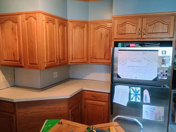 Bright kitchen with honey wood cabinets, white appliances, and tiled floor