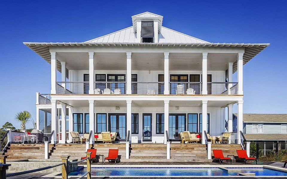 Beautiful white house with pool and red loungers luxe