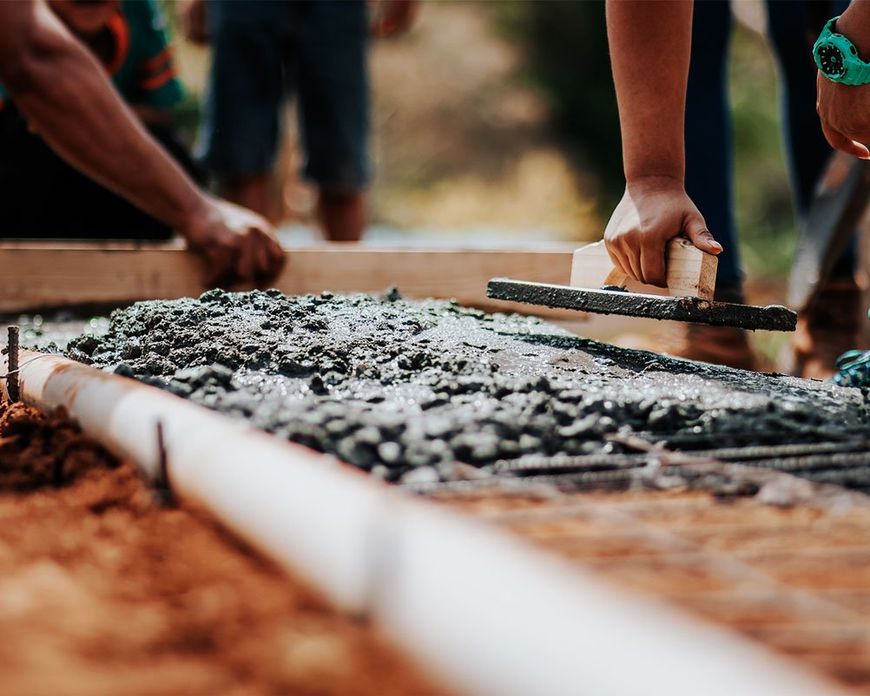 Builders starting project by laying concrete on floor