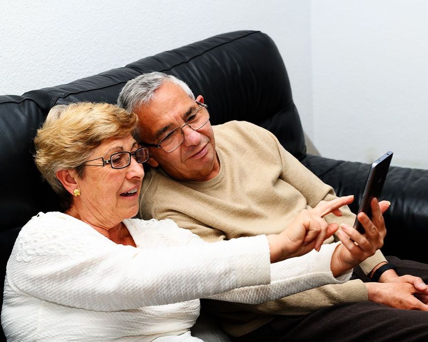 Senior couple sending message on mobile phone