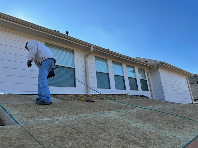 A man is working on the roof of a house.