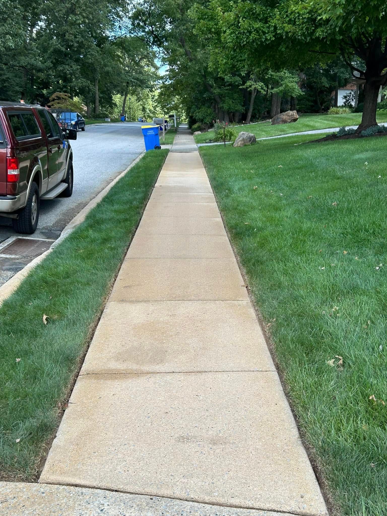 A sidewalk with a truck parked on the side of it.