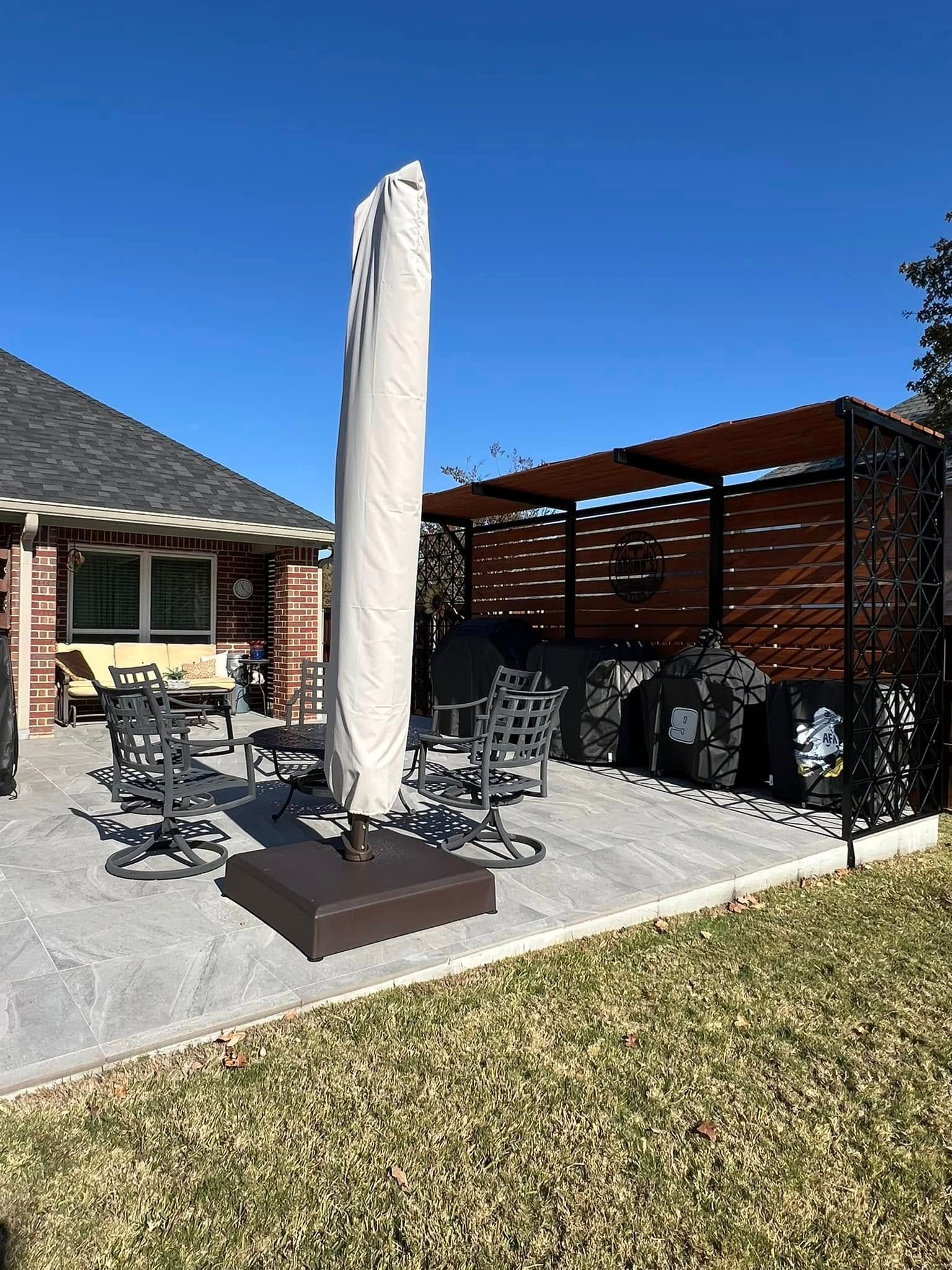 Patio with umbrella, furniture, and pergola against a sunny sky.
