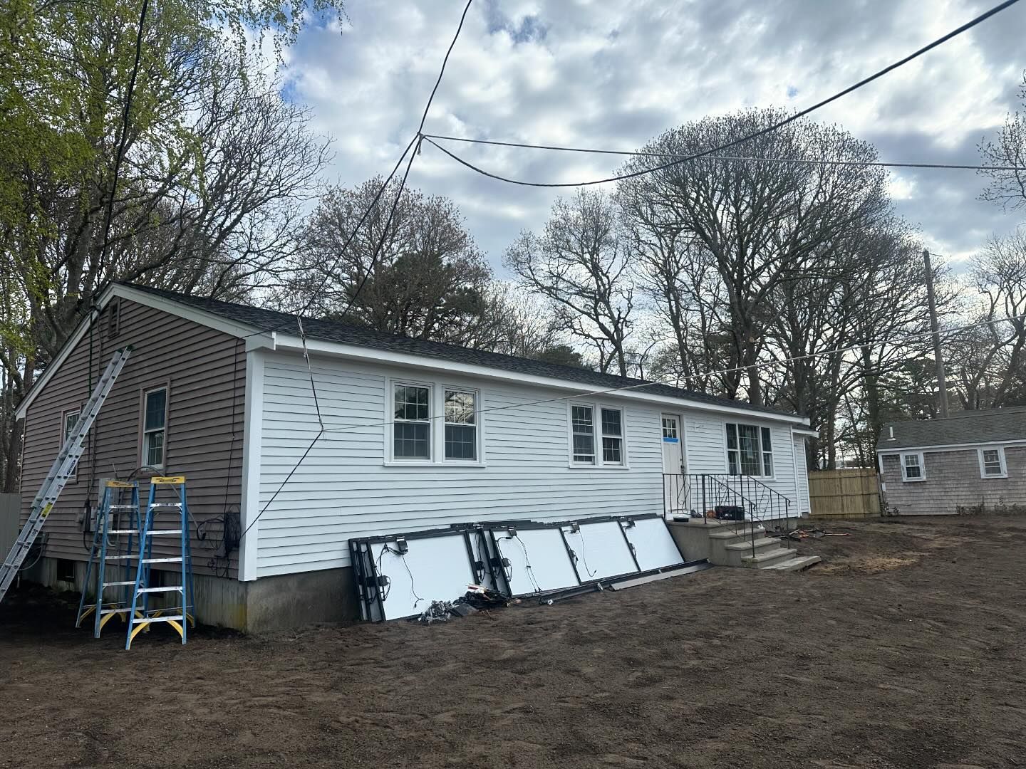 A white house with a ladder in front of it.