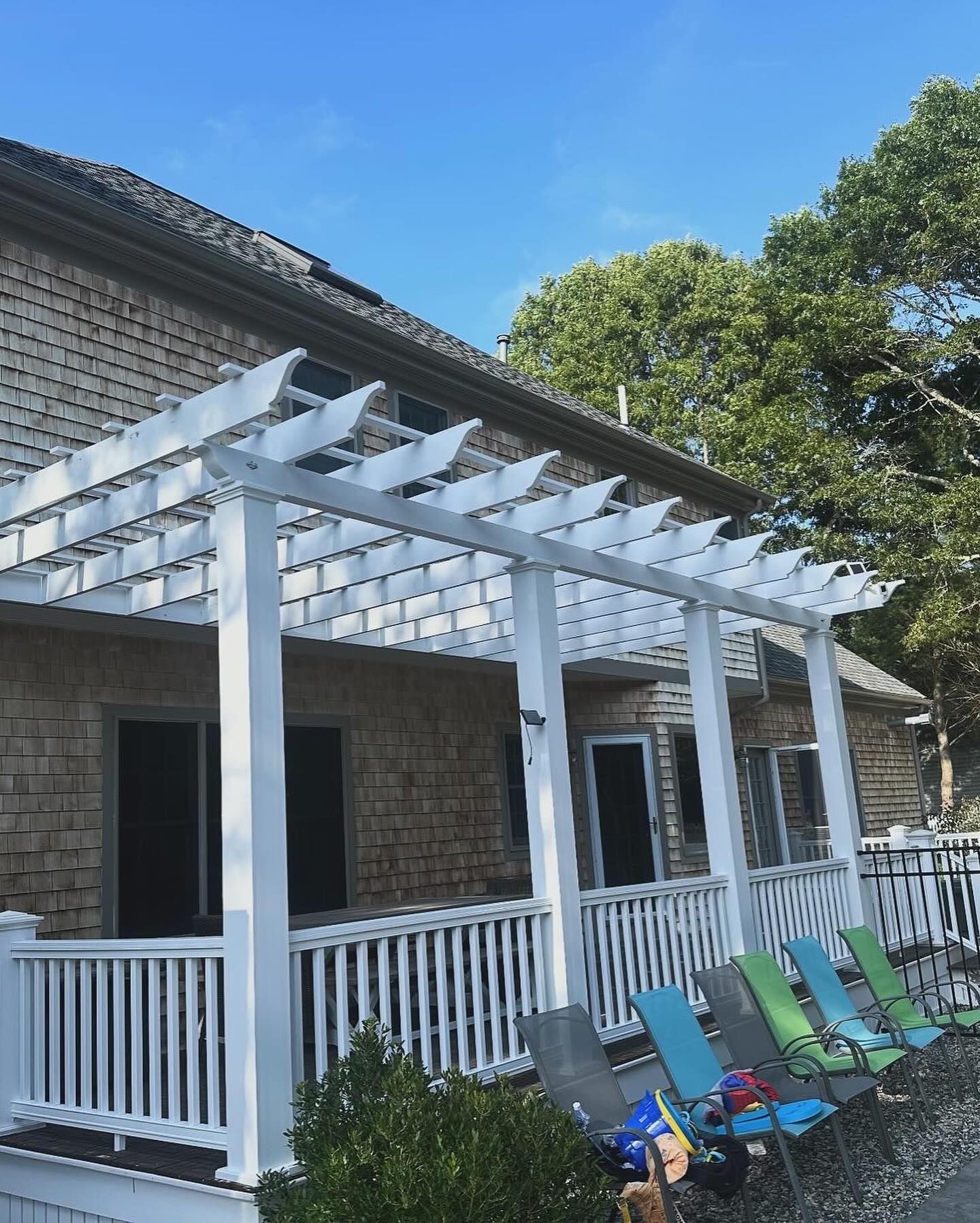 A house with a pergola and chairs on the porch