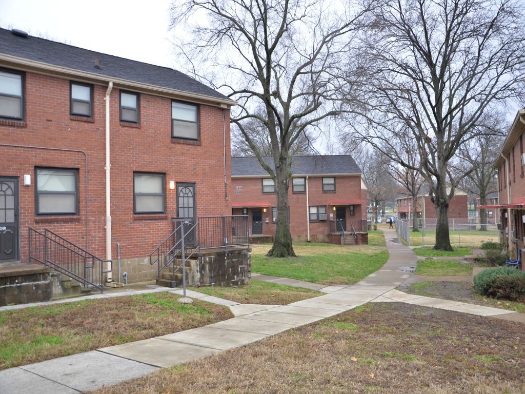 Red brick row houses with a pathway and bare trees.