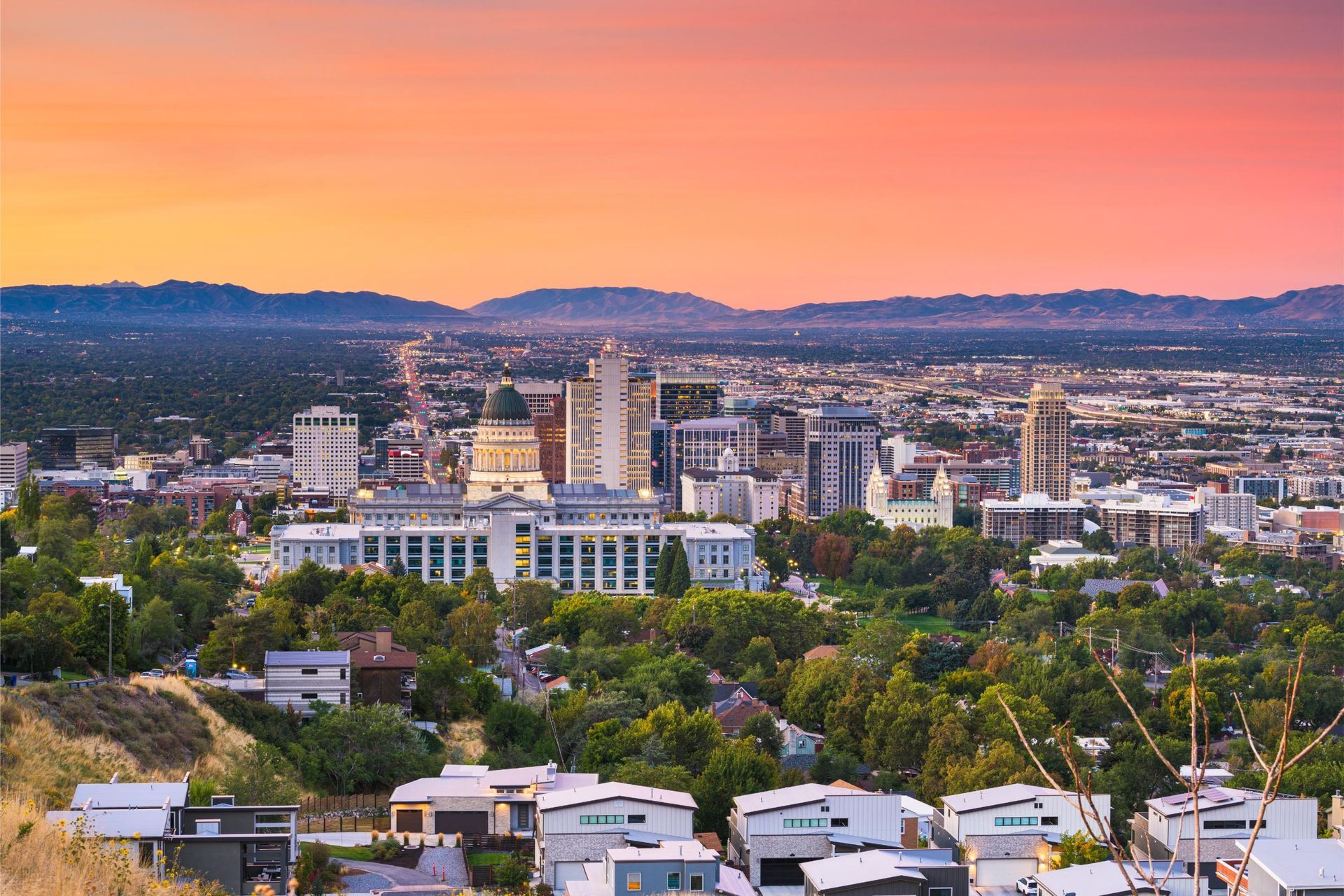 an aerial view of salt lake city with sunset in the background