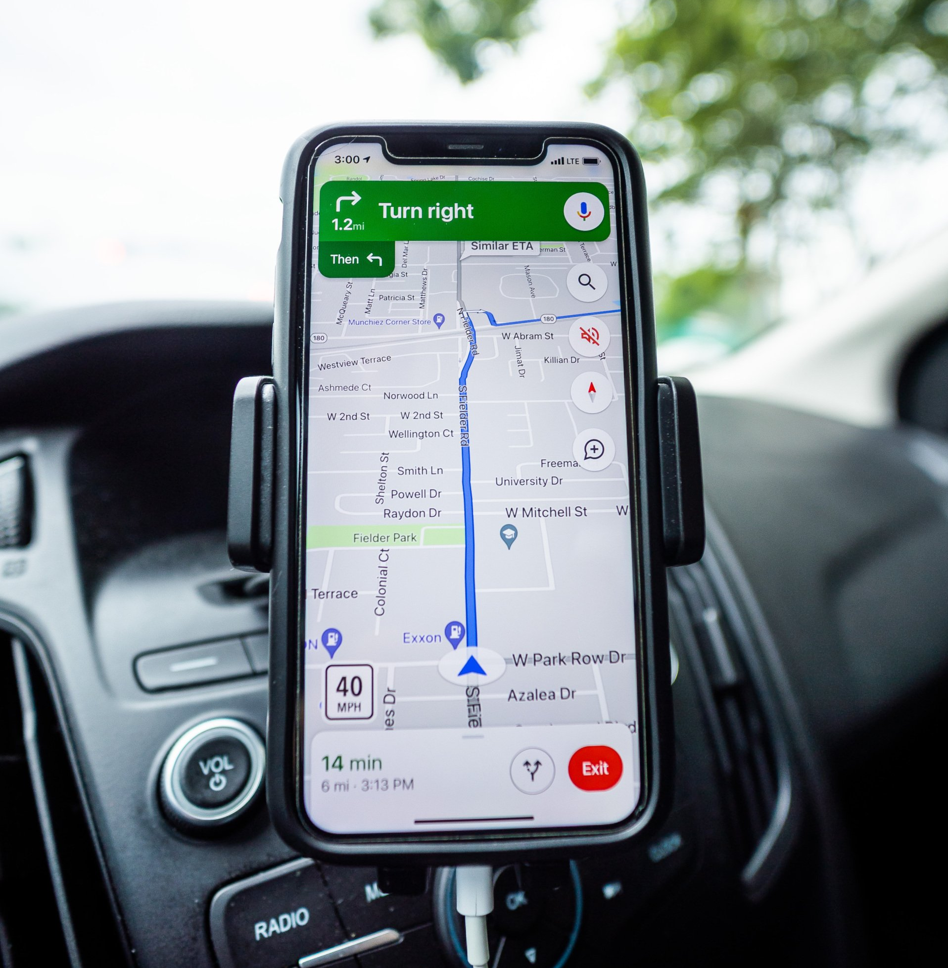 Smartphone in a car mount displaying a navigation app. Route direction on a road map.