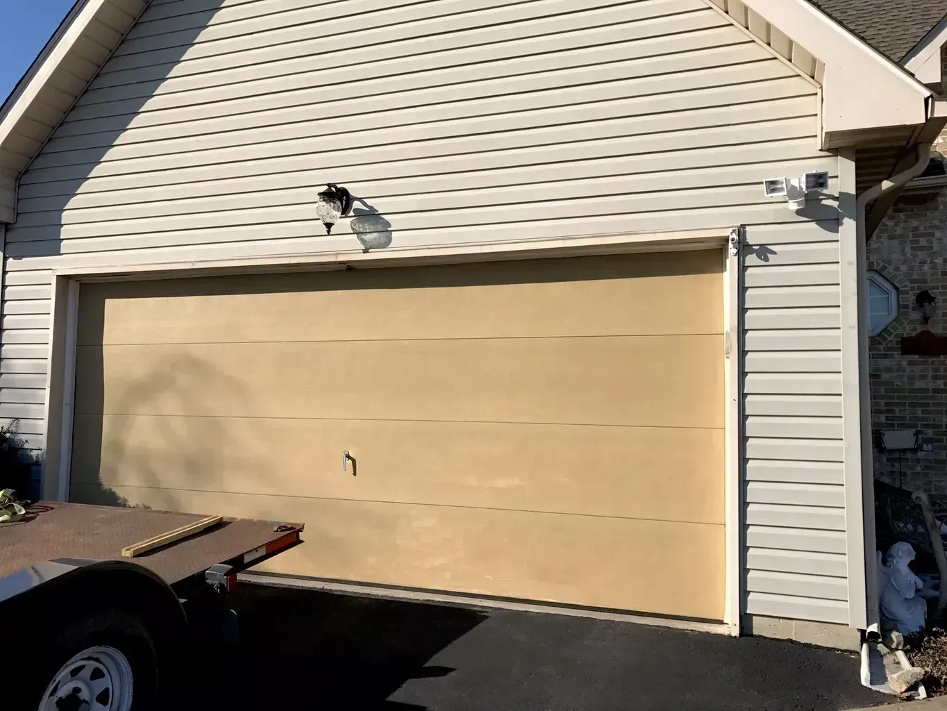 A car is parked in front of a garage door.