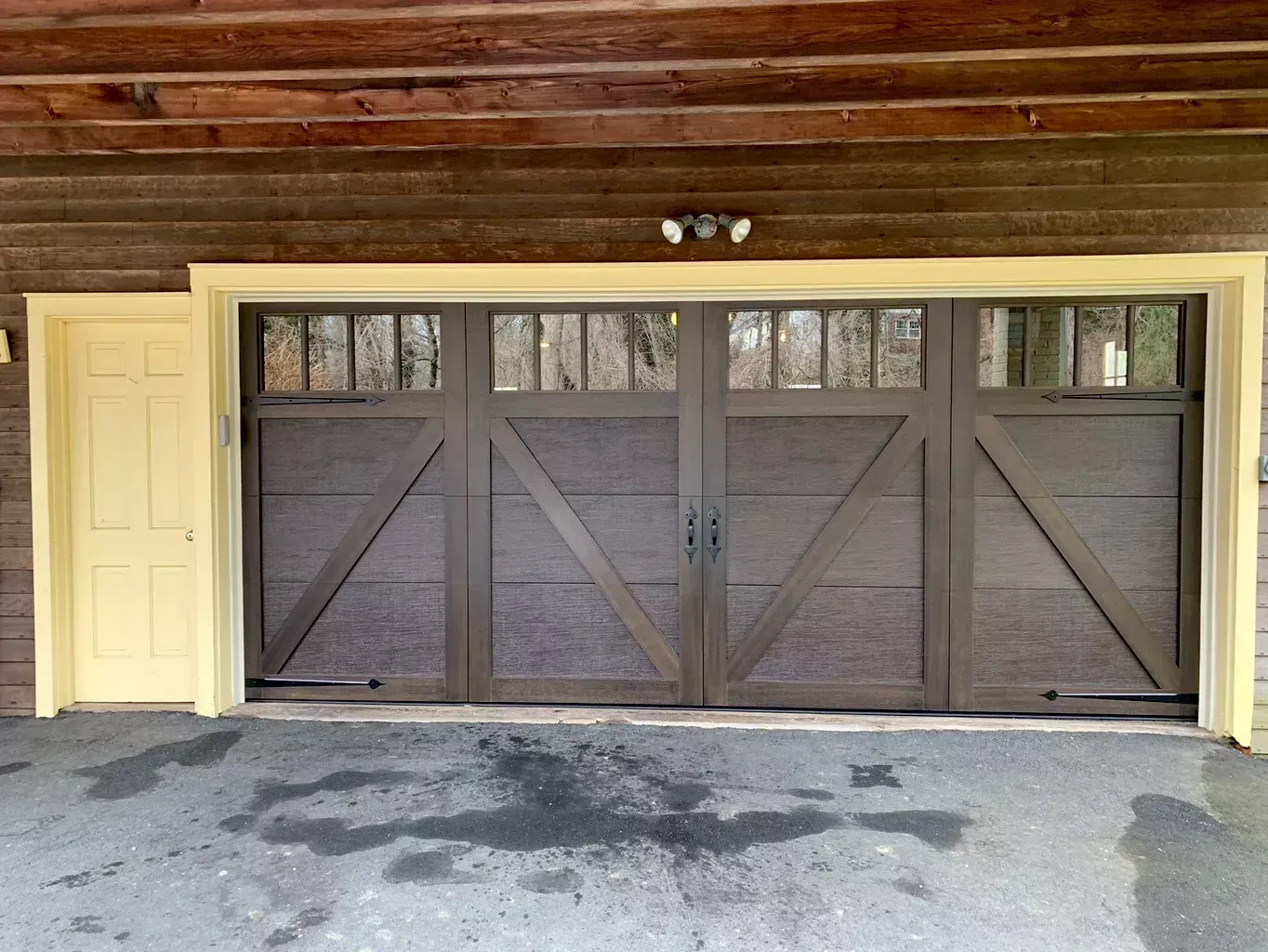 A brown garage door with a yellow door behind it