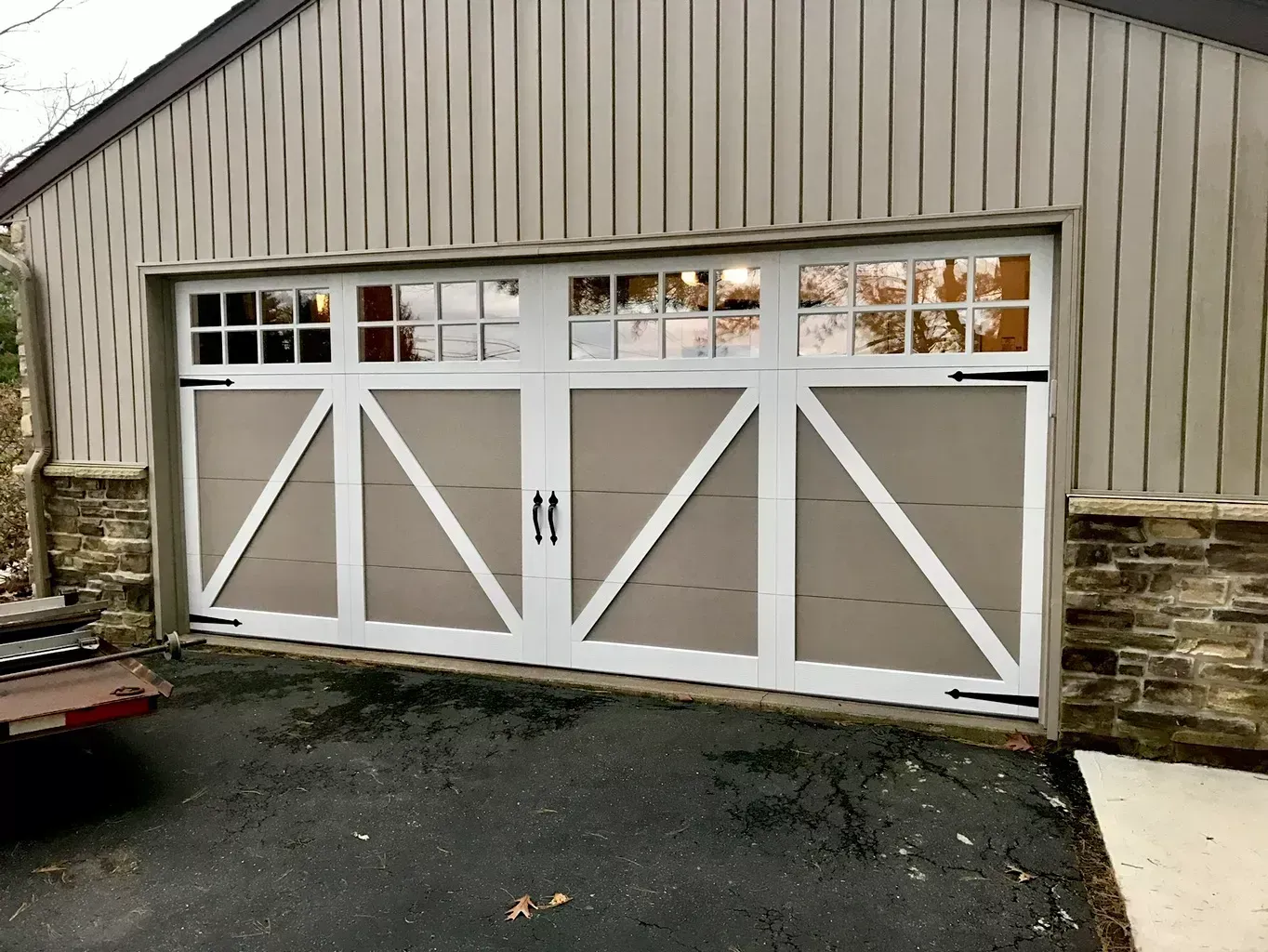 A white garage door is sitting on the side of a house.