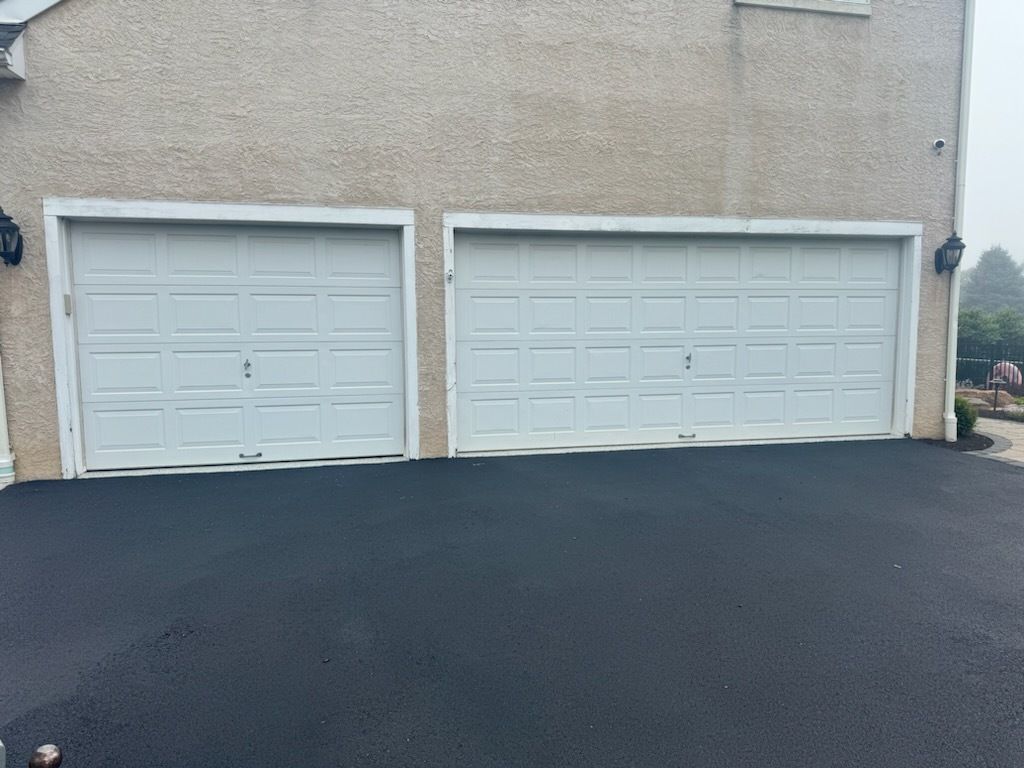 There are two garage doors on the side of a house.