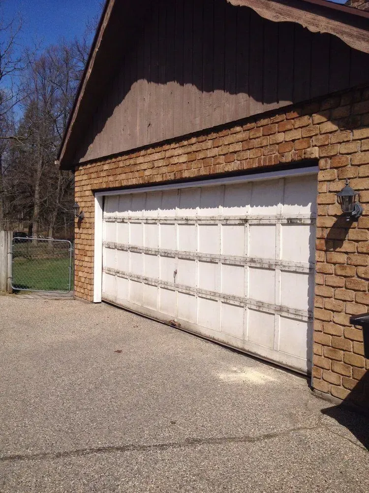 A brick garage with a white garage door