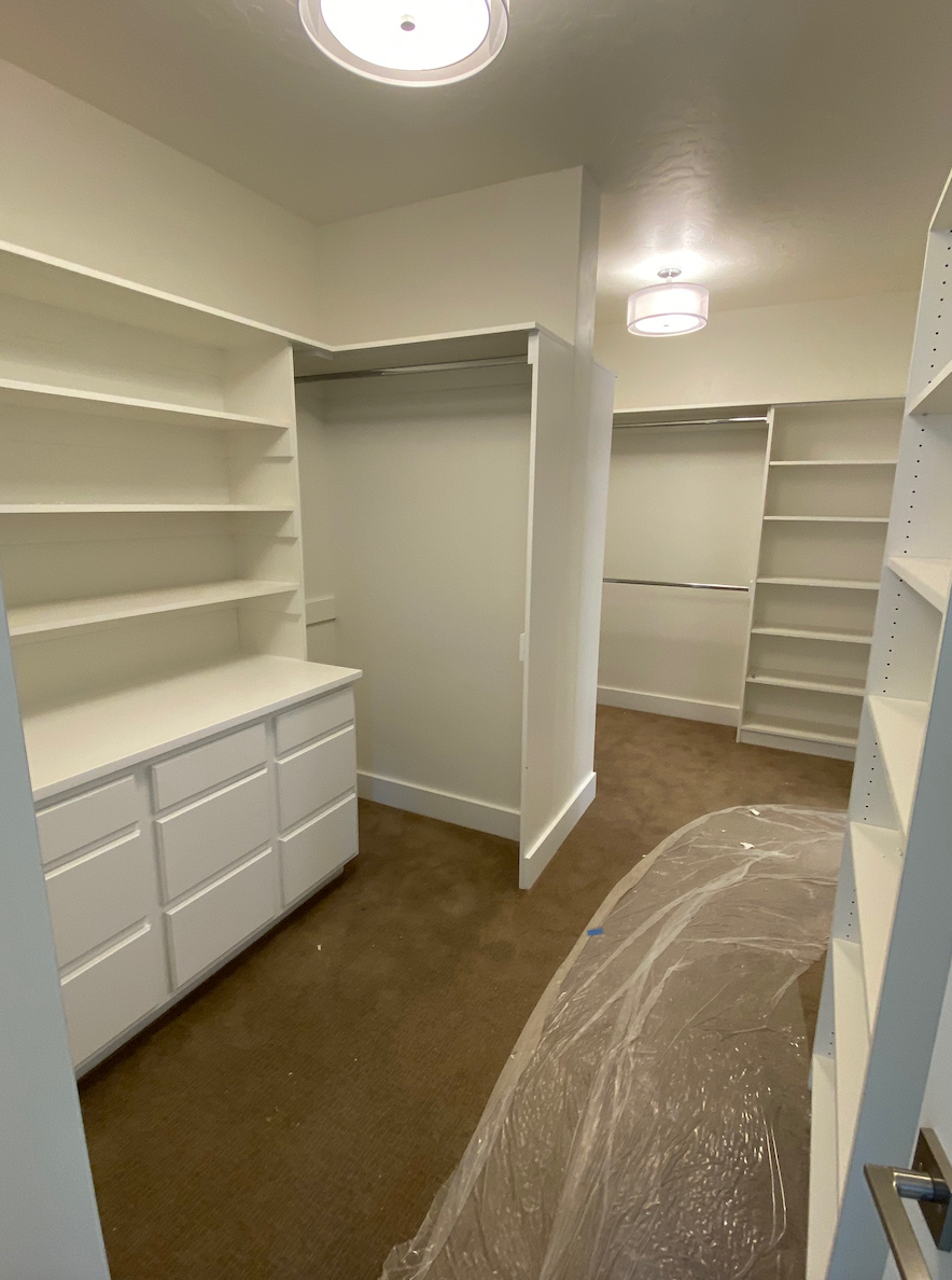 A walk in closet with lots of shelves and drawers.