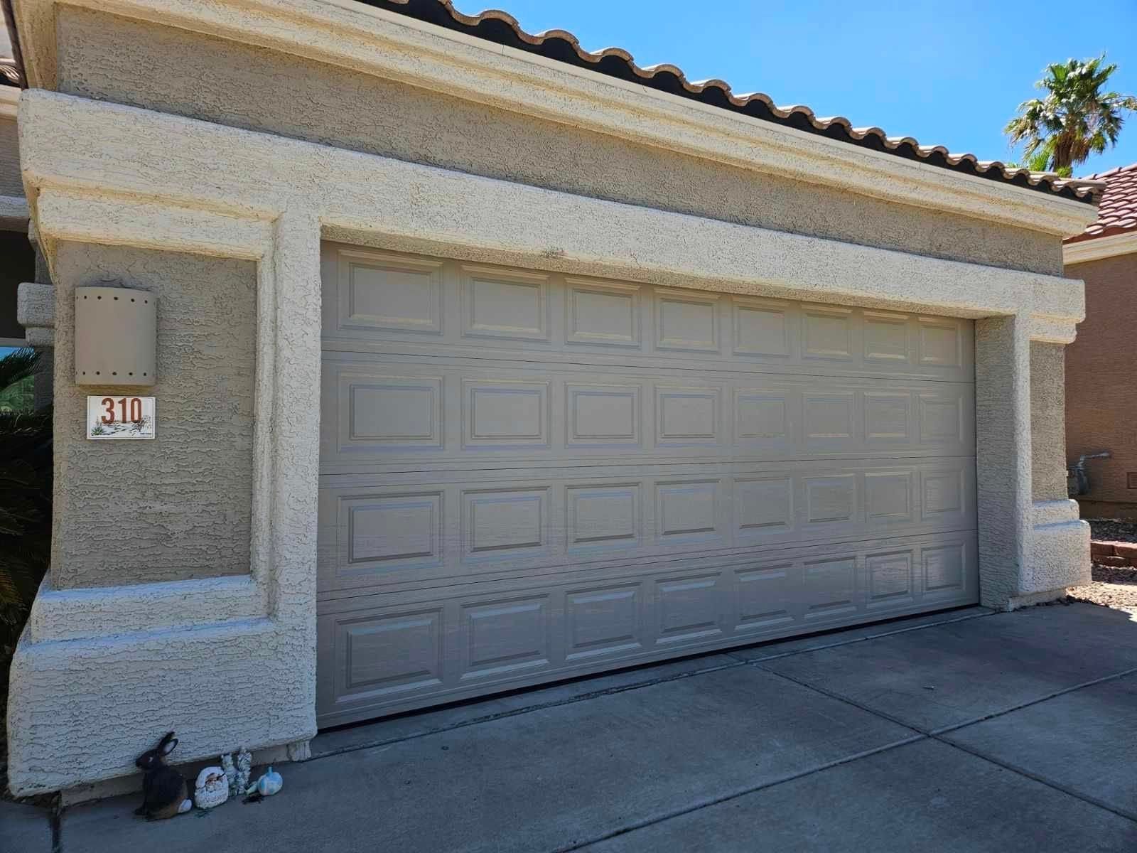 A large garage door is sitting in front of a house.