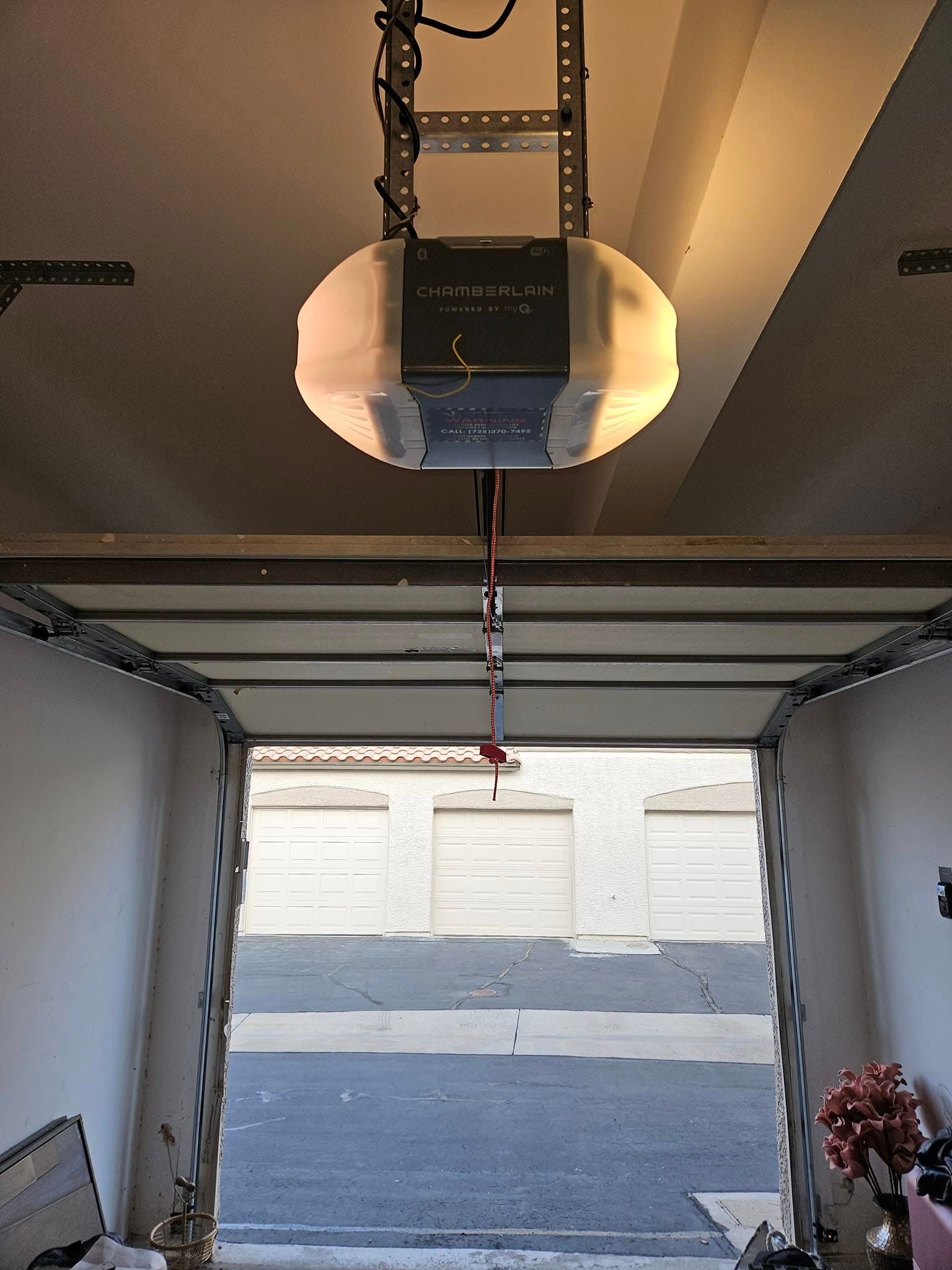 A garage door opener is hanging from the ceiling of a garage.